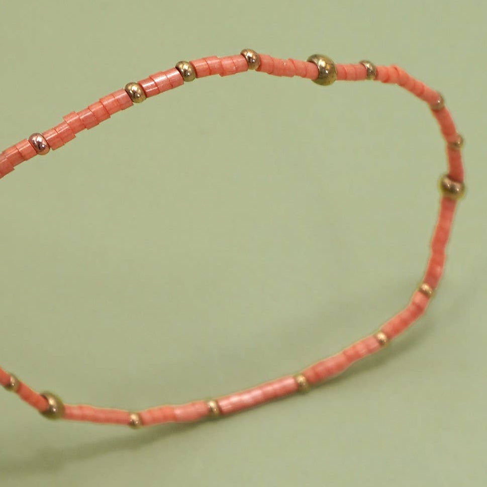 Necklace with pink beads on a green background