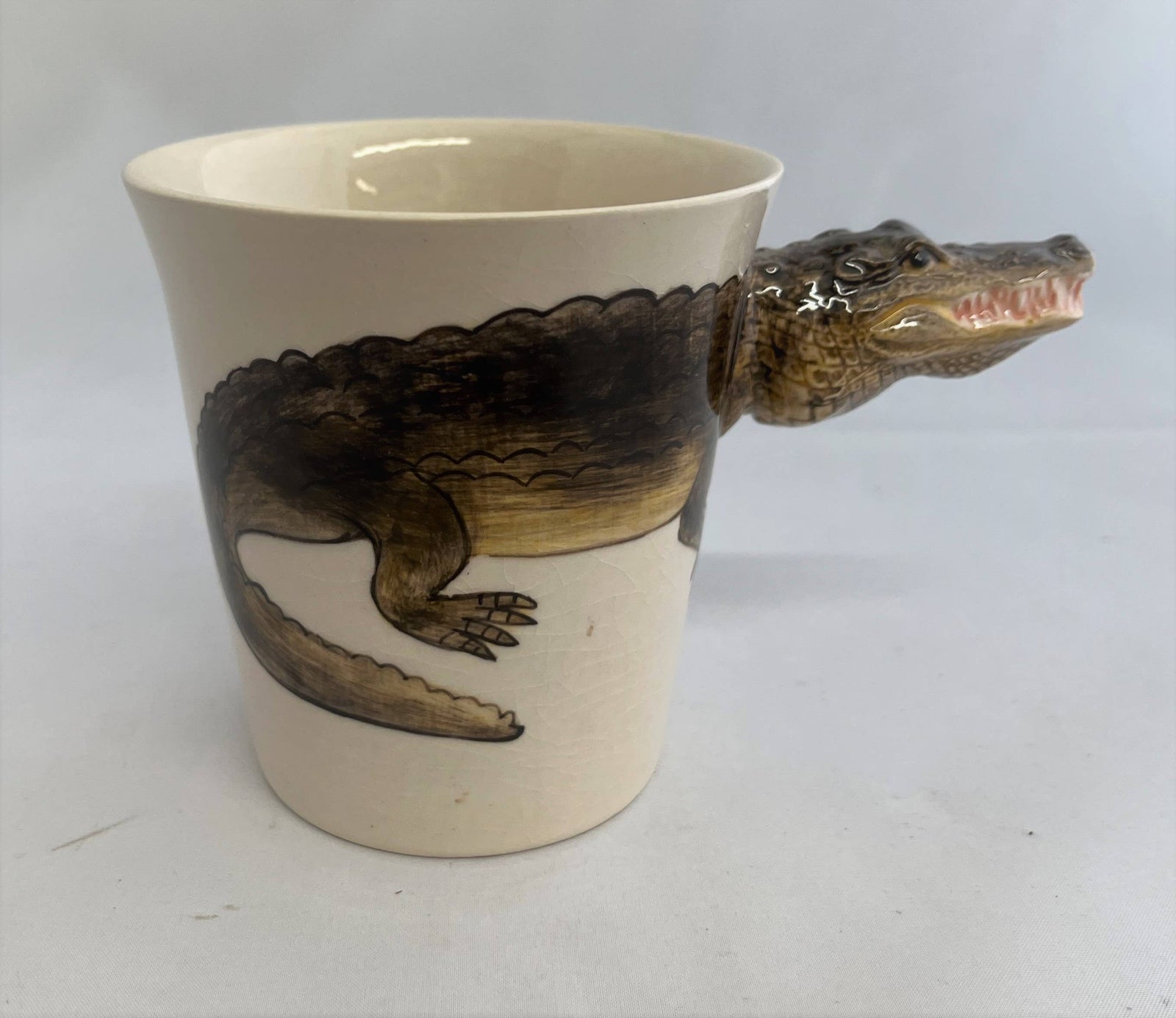 Ceramic mug with alligator design on a white background