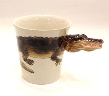 Ceramic mug with alligator design on a white background