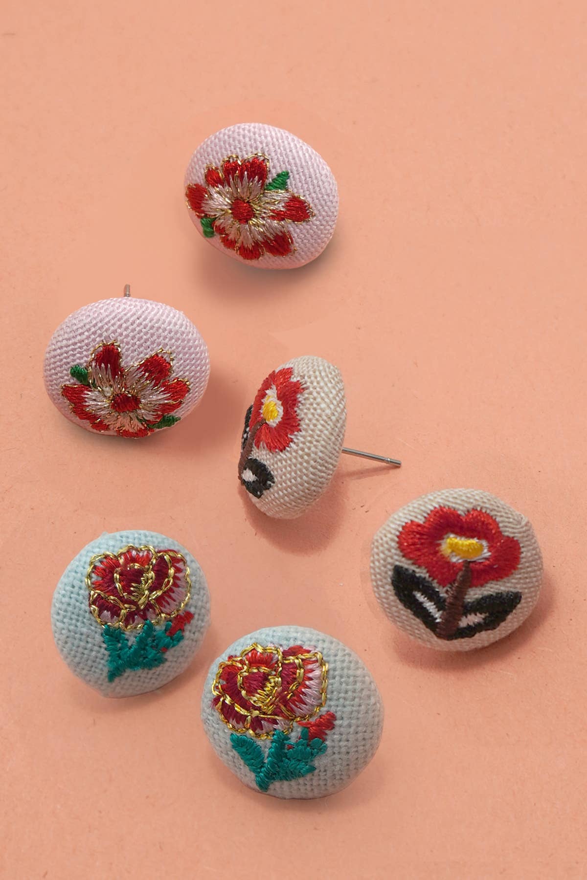 Floral embroidered earrings on a peach background