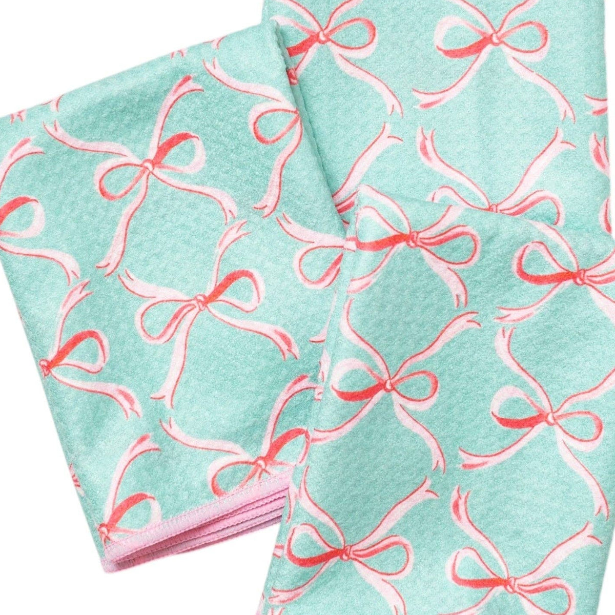 Two turquoise dish cloths with pink bow patterns on a white background