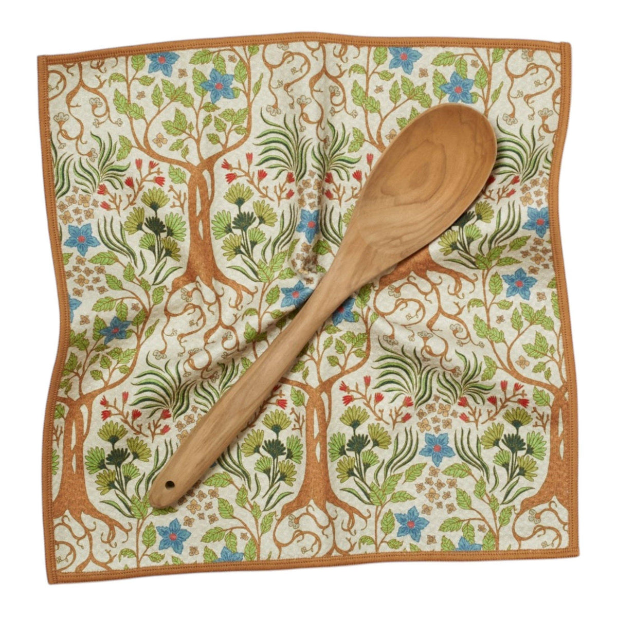 Wooden spoon on a decorative cloth with tree and floral pattern