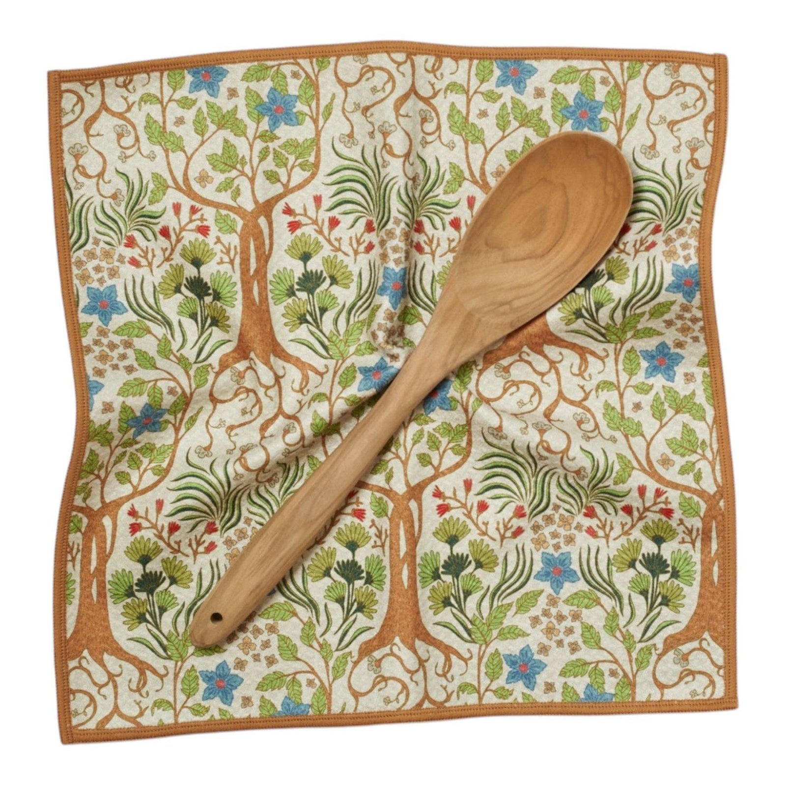 Wooden spoon on a decorative cloth with tree and floral pattern