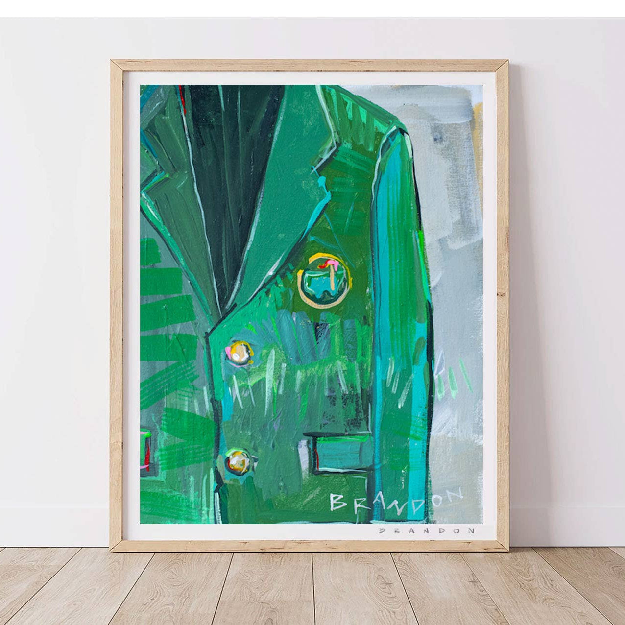 Framed painting of a green jacket with a brand logo on a white wall.