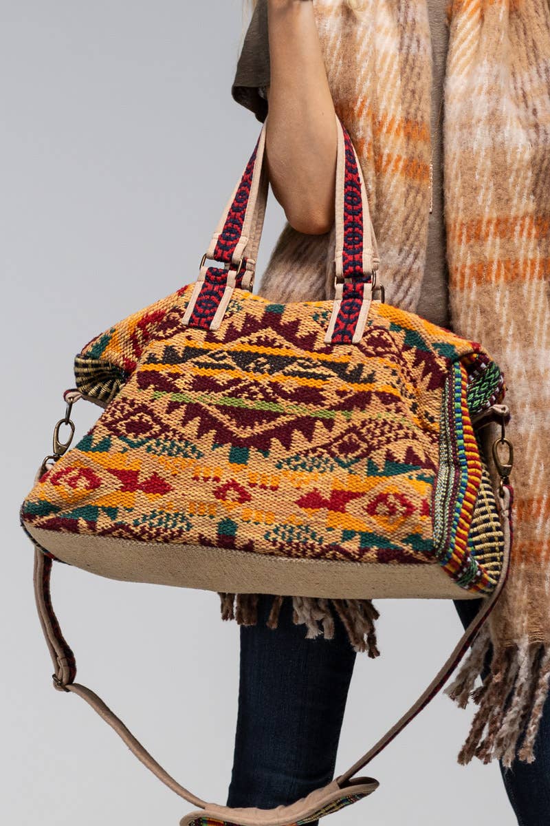 Colorful patterned handbag with a strap on a white background