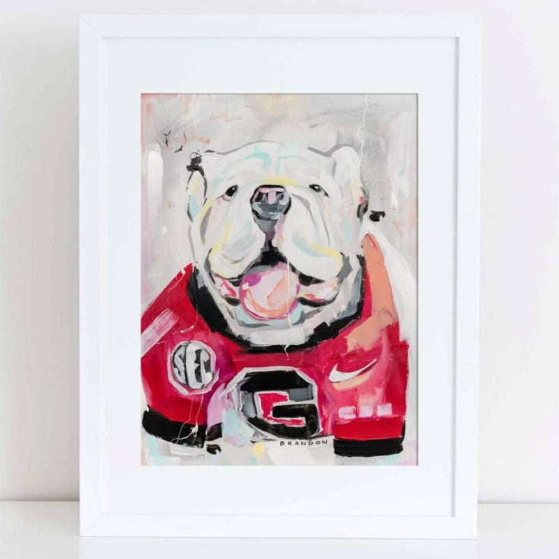 Framed artwork of a bulldog wearing a red jersey with a logo on a white background