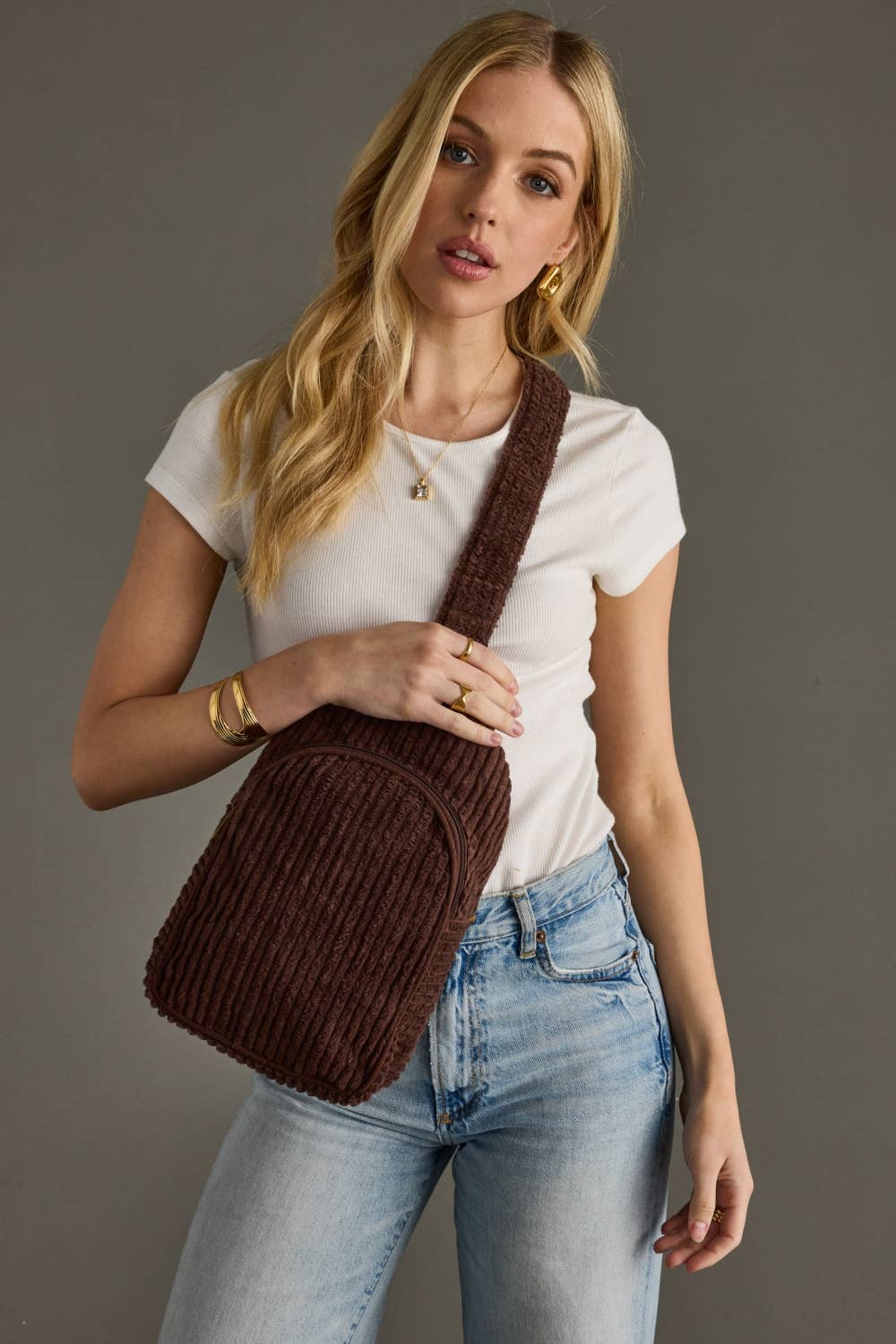 Person wearing a brown knitted backpack against a plain background