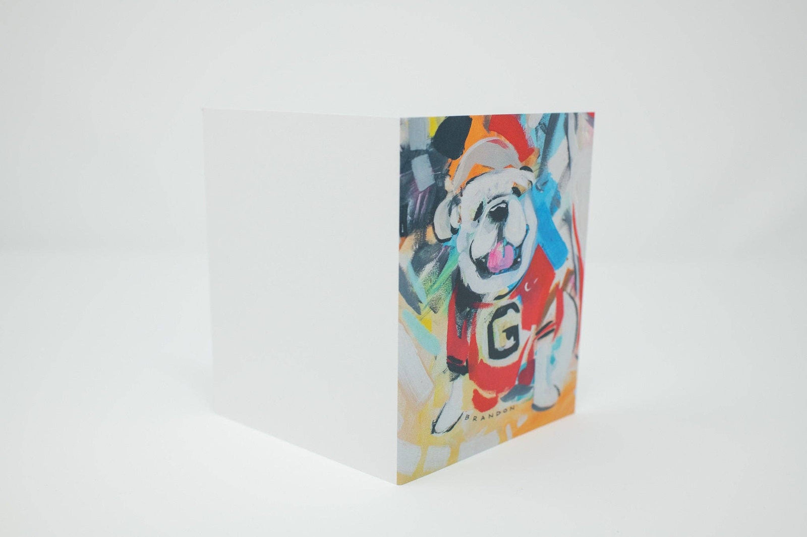 A set of colorful pop-art dog paintings, with several individual prints fanned out above a stack of matching art prints on a white background.