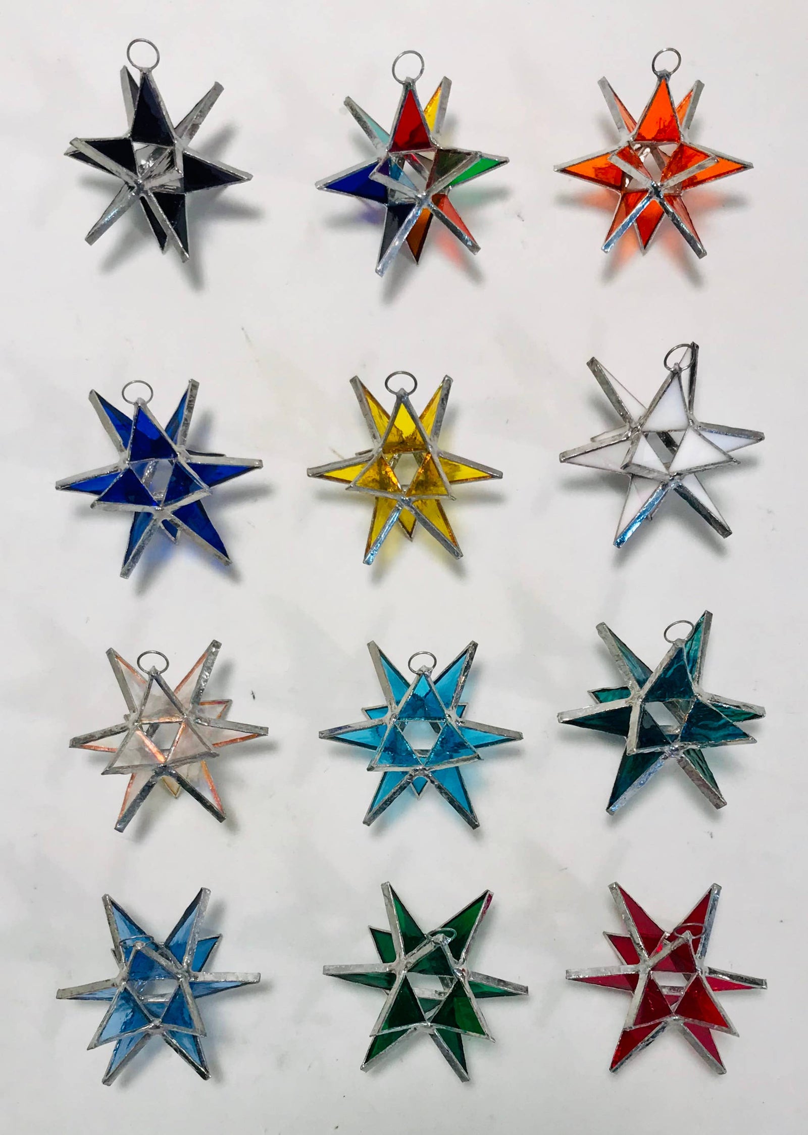 Star-shaped glass ornament with metallic accents on a white background