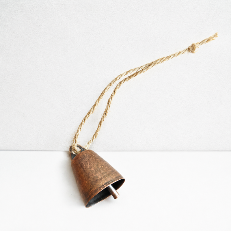 A small rustic bronze bell with a natural jute hanging rope, photographed on a clean white background.