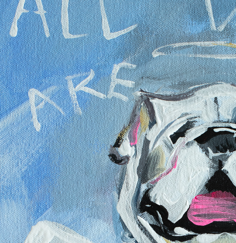 A framed art print featuring a painted bulldog wearing a red football jersey with the letter G, set against a blue sky with white text reading 'ALL DOGS ARE DAMN GOOD.' The print is displayed in a light wood frame leaning against a white wall on a light wood floor.