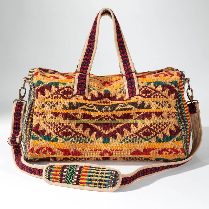 Colorful patterned handbag with a strap on a white background
