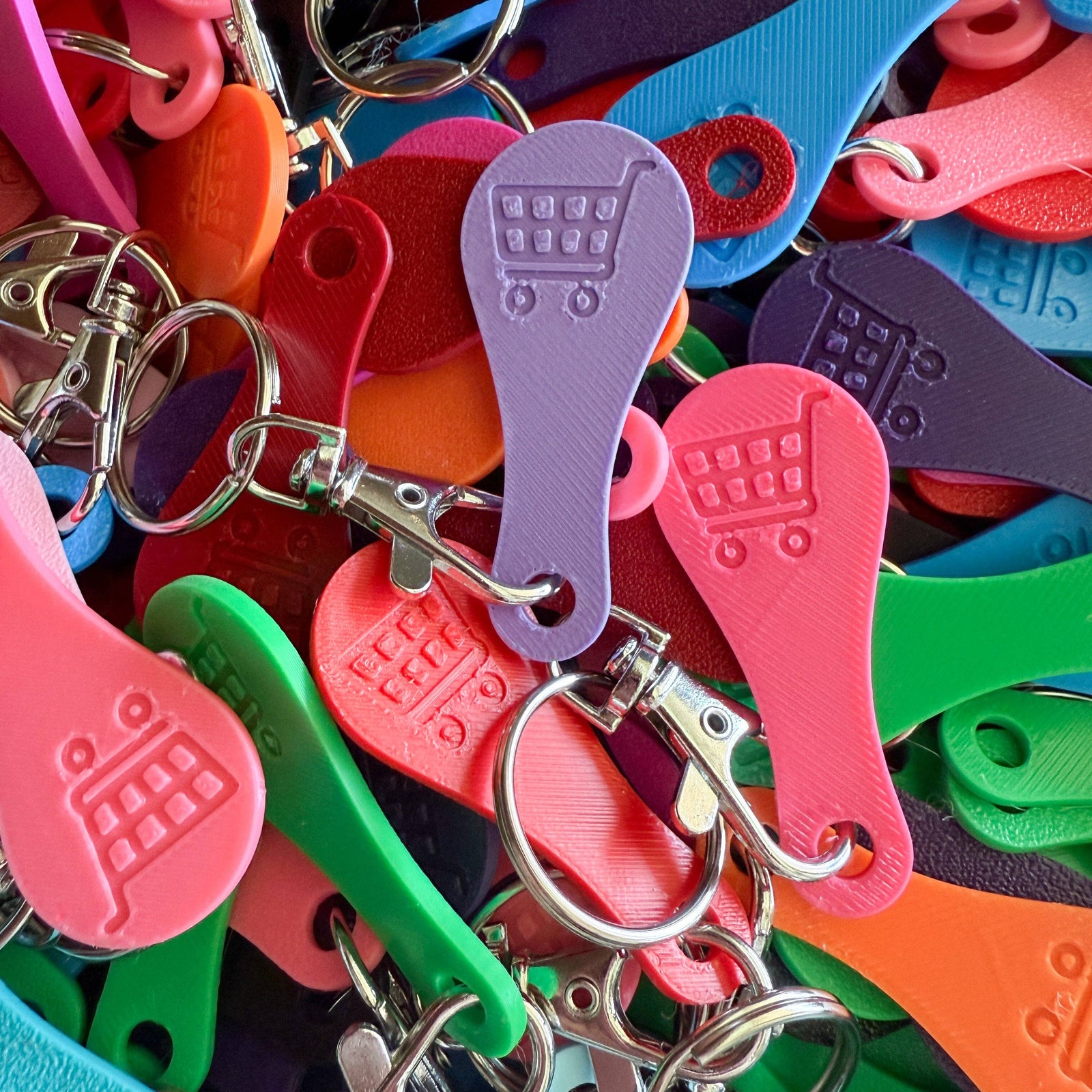 Aldi Colorful keychains with various shapes and designs on a multicolored background