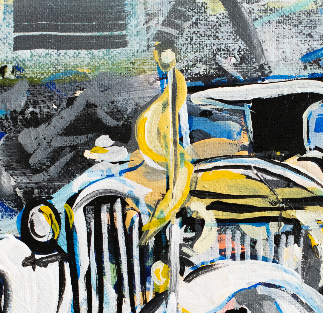 A framed abstract art print depicting a vintage yellow and white truck, leaning against a white wall on a light wood surface.