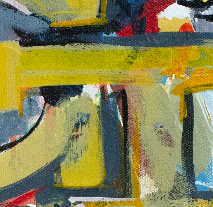 A framed abstract art print leaning against a white wall on a light wood floor. The artwork features a large yellow and gray stylized letterform over a multicolored abstract background with blue, green, orange, black, and white elements.