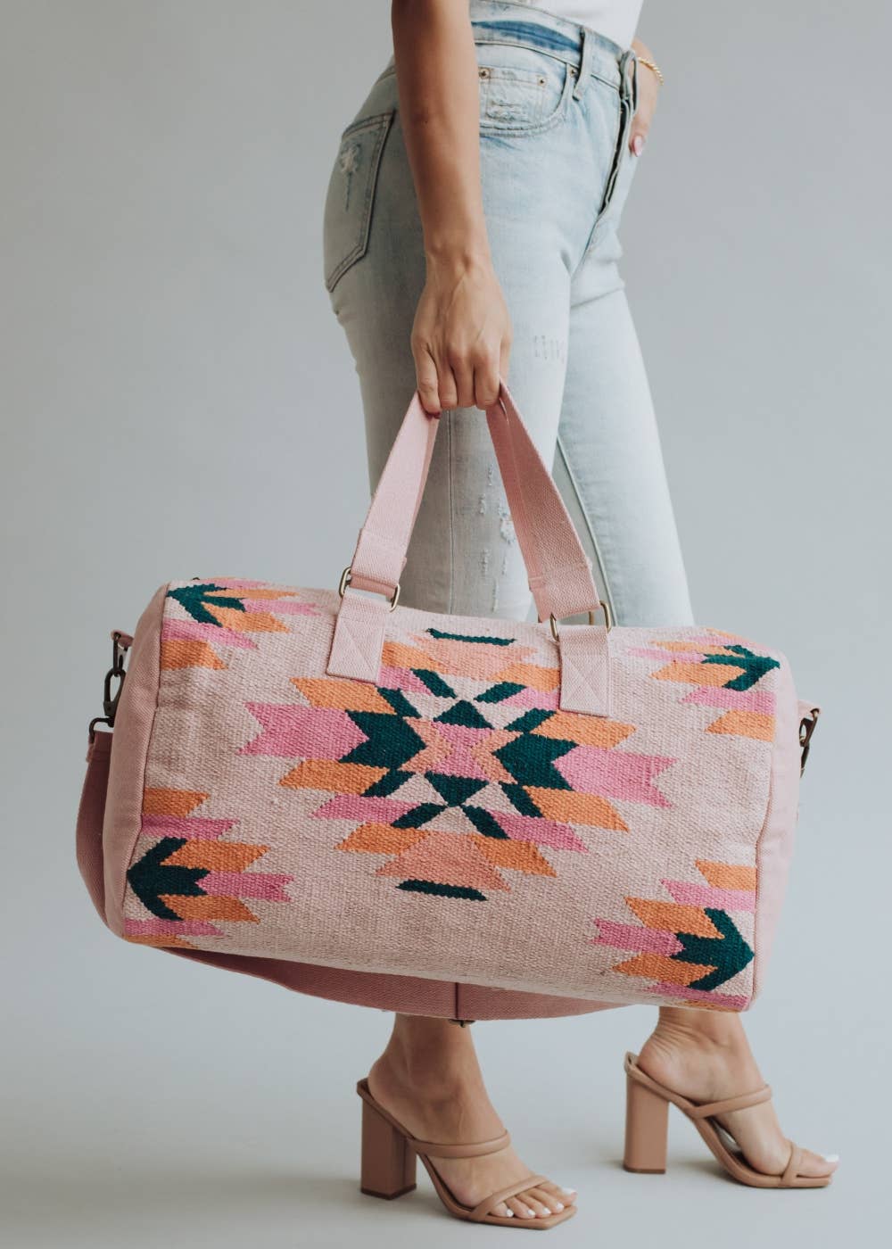 Person holding a colorful patterned bag against a plain background