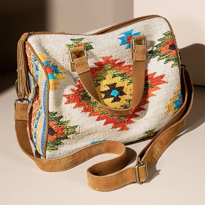 Colorful embroidered handbag with a brown strap on a beige background