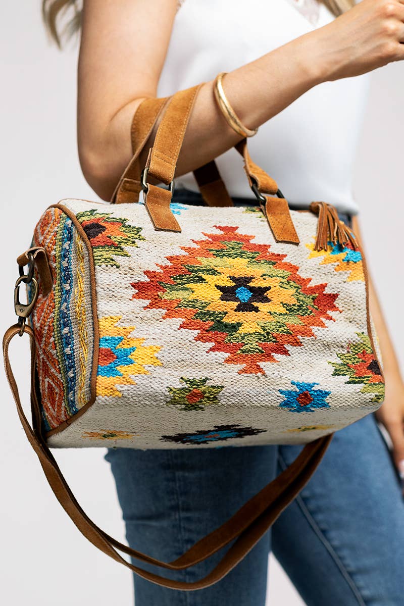 Colorful embroidered handbag with a brown strap on a beige background